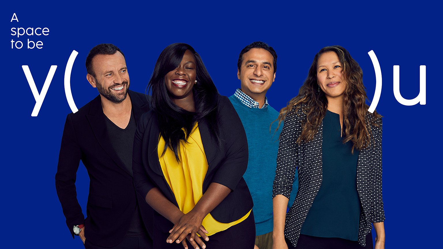 Four associates smiling with the "A space to be you" backdrop behind them