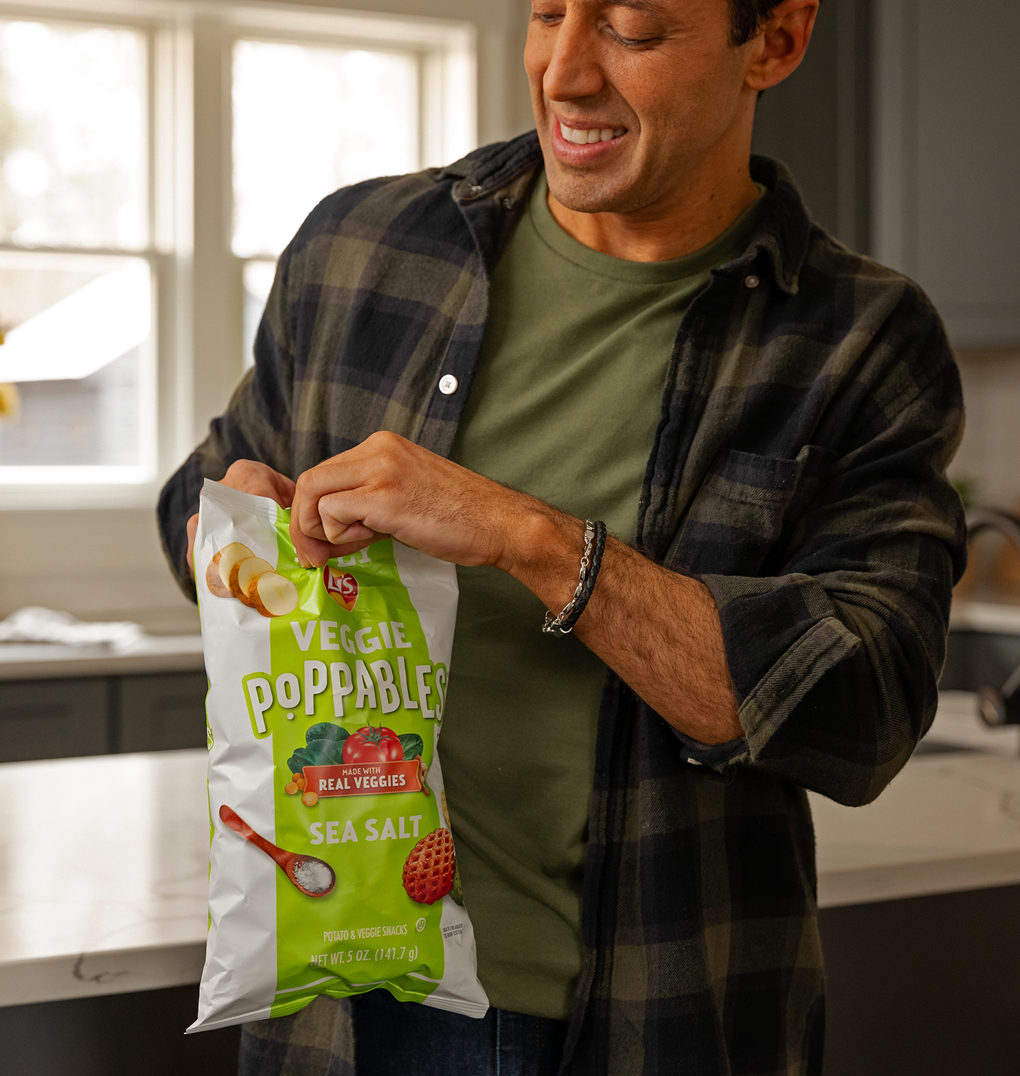 Man opening a bag of Lay's Veggie Poppables