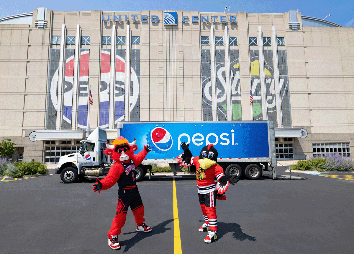 Chicago Bulls and Chicago Blackhawks mascots stand in front of a Pepsi truck in front of the United Center arena. The United Center arena displays the Pepsi and Starry logos on its outer walls.