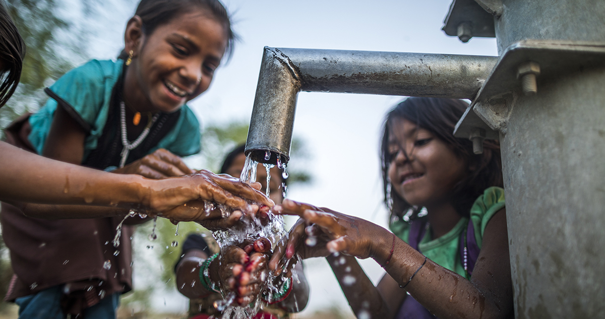 Children wash their hands at a hand pump installed in Uttar Pradesh, India.