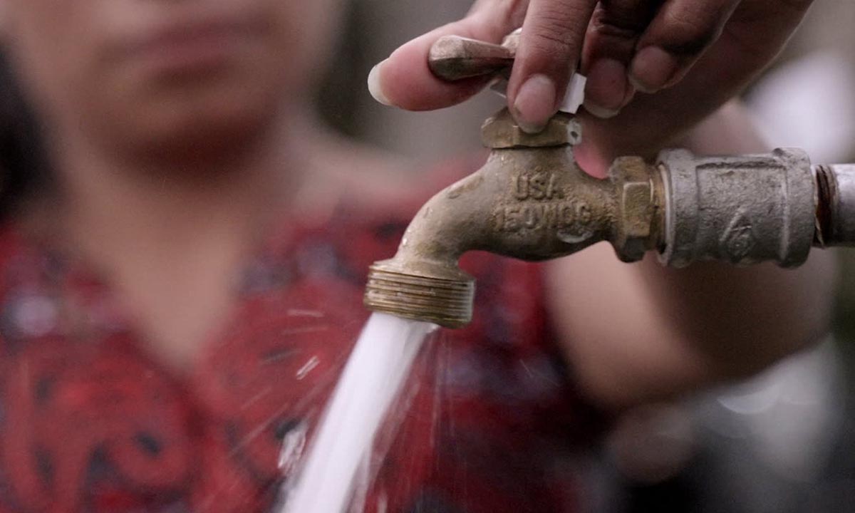 Hand turns water spigot on
